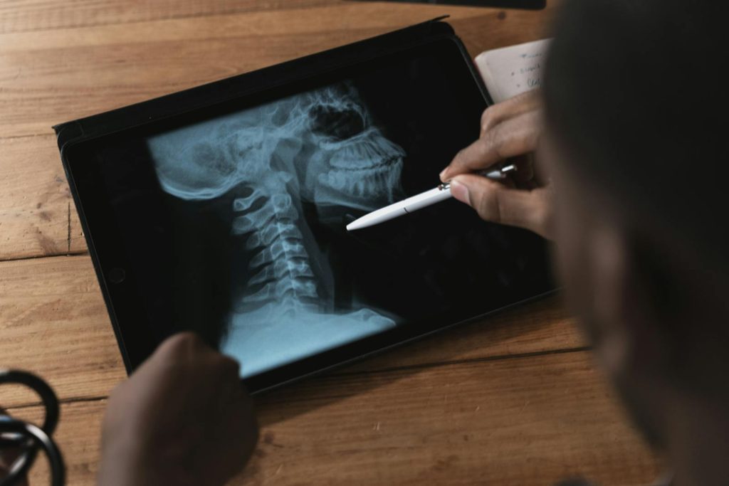 Doctor examining a spinal x-ray on a tablet using a stylus. Modern medical analysis.